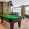 Spacious and well lit game room with billiard tables and plenty of seating.
