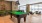 Spacious and well lit game room with billiard tables and plenty of seating.