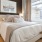Spacious and well lit bedroom with wood floors and a large window