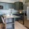 Spacious and well lit kitchen with wood floors and stainless steel appliances. 