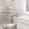 Large well lit bathroom with designer tile floors and backsplash and white custom counters