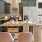 Spacious and well lit kitchen with wood floors and stainless steel appliances. 