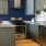 Spacious and well lit kitchen with wood floors and stainless steel appliances. 
