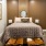 Large well lit bedroom with tan carpet and a ceiling fan.