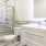 Large well lit bathroom with designer tile floors and backsplash and white custom counters