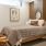 Large well lit bedroom with tan carpet and a ceiling fan.