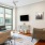 Spacious and well lit living room with wood floors and an open floor plan with access to the kitchen.