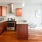 Spacious and well lit kitchen with wood floors and stainless steel appliances. 