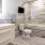 Large well lit bathroom with designer tile floors and backsplash and white custom counters